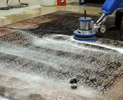 Professional rug cleaning with a rotary floor machine and shampoo foam, deep-cleaning an area rug, in Spokane, WA.